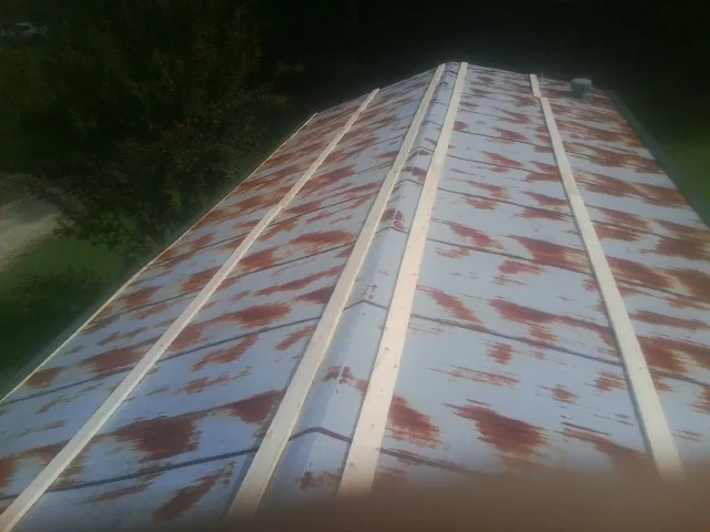Rusted metal roof panels with new wood purlins before replacement — Storm Damage Roof Repair in Apopka by Roofing Brothers